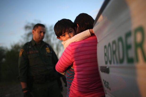 A one-year-old from El Salvador clings to his mother after she turned themselves in to Border Patrol agents on December 7, 2015 near Rio Grande City, Texas (Getty/John Moore)