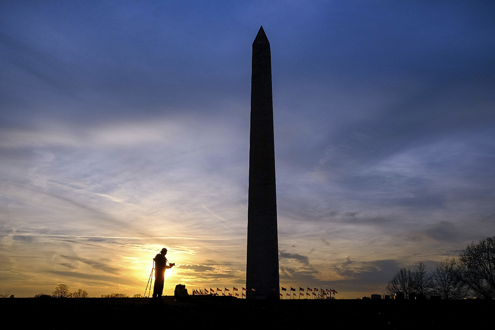 Silhouetted in the setting sun, a photographer works with his camera in the shadow of the Washington Monument, Tuesday, Feb. 21, 2017. The monument to honor the first U.S. President, George Washington, was dedicated 132 years ago today on Feb. 21, 1885. It was open to the public three years later and remains by law the tallest structure in the District of Columbia. (AP Photo/J. David Ake) (AP)