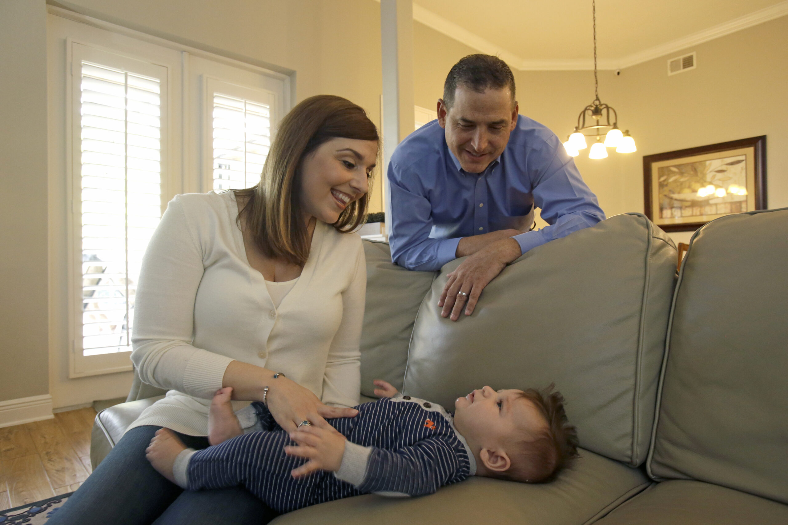In this Tuesday, Feb. 7, 2017 photo, Lauren Nieves-Taranto, left, and husband Francisco play with their youngest child Nicolas, 4-months, at their home in Windermere, Fla. Nieves-Taranto covered the entire $8,000 bill from the birth of Nicolas last year with his account balance from a health savings account, or HSA. () (AP Photo/John Raoux)