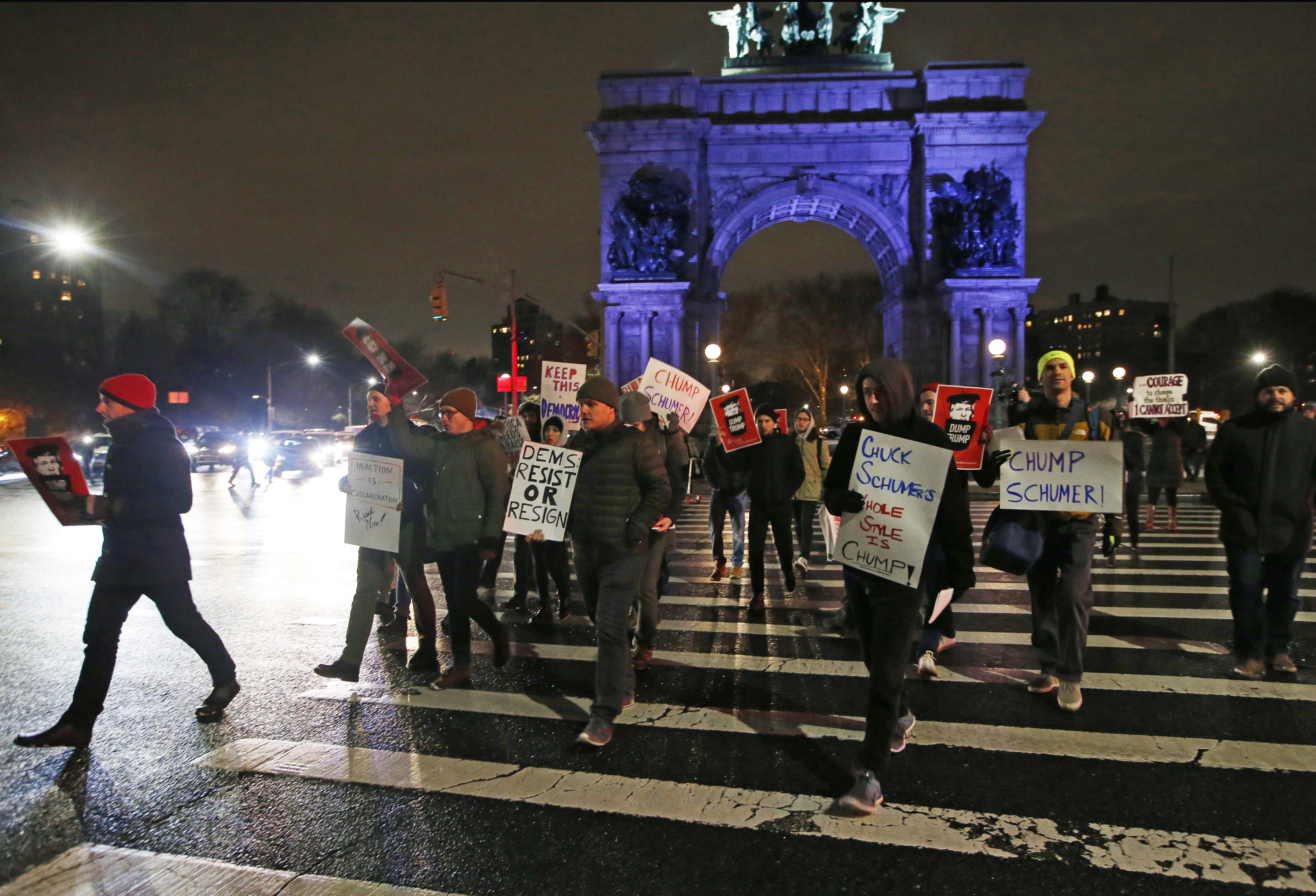 In this Tuesday, Jan. 31, 2017 photo, demonstrators protesting Senate Minority leader Chuck Schumer hold signs and chant as they march across the traffic circle at Brooklyn's Grand Army Plaza during a protest in New York. Liberals are vowing to put pressure on Schumer to mount a vigorous opposition to the agenda of President Donald Trump. (AP Photo/Kathy Willens) (AP Photo/Kathy Willens)
