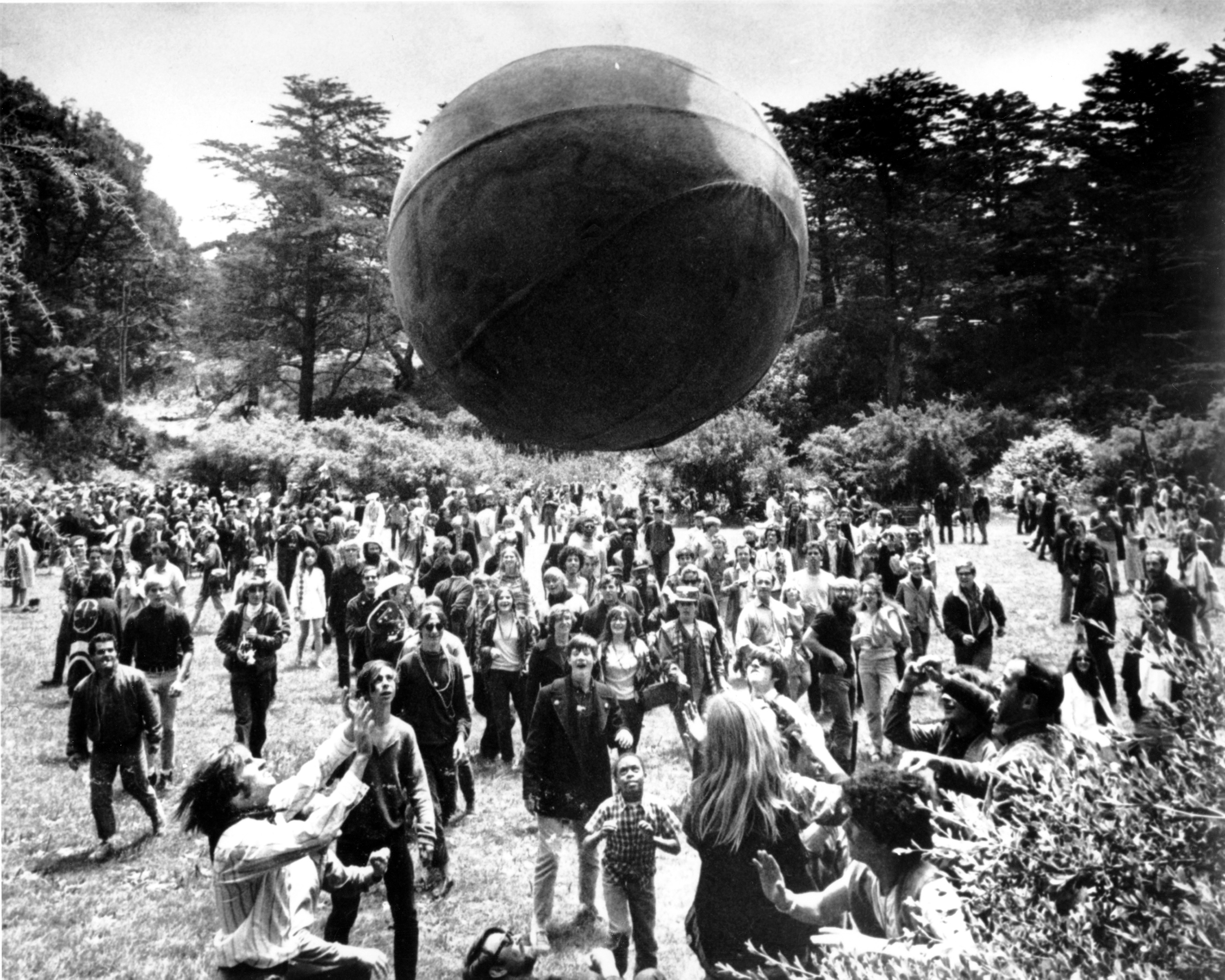 FILE - In this June 21, 1967, file photo, a crowd of hippies keep a large ball, painted to represent a world globe, in the air during a gathering at Golden Gate Park in San Francisco, to celebrate the summer solstice on June 21, day one of "Summer of Love." (AP Photo, File)
