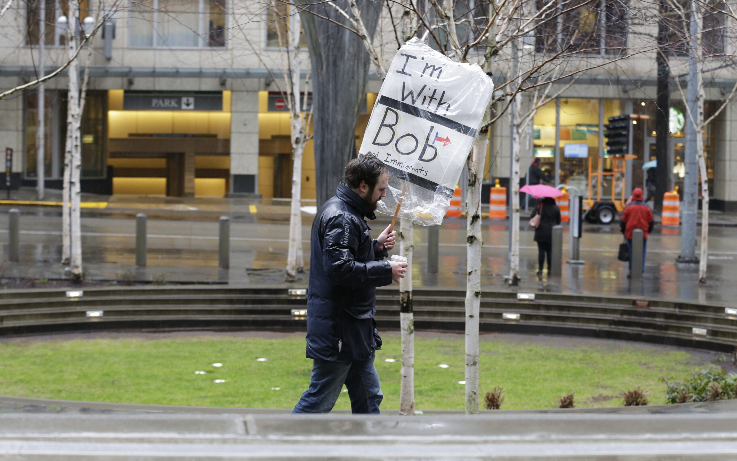 A person walks outside the federal courthouse in Seattle carrying a sign that reads "I'm with Bob and Immigrants," in reference to Washington state Attorney General Bob Ferguson, Friday, Feb. 3, 2017, during a hearing in federal court. A U.S. judge on Friday temporarily blocked President Donald Trump's ban on people from seven predominantly Muslim countries from entering the United States after Washington state and Minnesota urged a nationwide hold on the executive order that has launched legal battles across the country. (AP Photo/Ted S. Warren) (AP)
