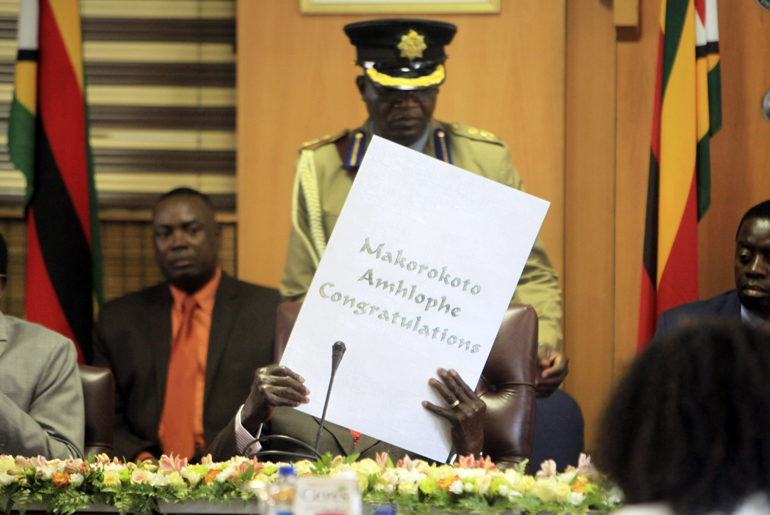Zimbabwe's President Robert Mugabe reads his birthday card as he marks his 93rd birthday at his offices in Harare, Tuesday, Feb. 21, 2017. Mugabe described his wife Grace, an increasingly political figure, as "fireworks" in an interview marking his 93rd birthday. (AP Photo/Tsvangirayi Mukwazhi) (AP)