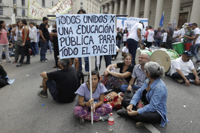 A teacher holds a sign with a message that reads in Spanish: "All united for public education for the entire country", during a protest demanding higher wages in Buenos Aires, Argentina, Wednesday, March 22, 2017. Tens of thousands of teachers marched to Plaza de Mayo, the park overlooking the presidential palace, during their fourth day of national strike. (AP Photo/Victor R. Caivano) (AP)