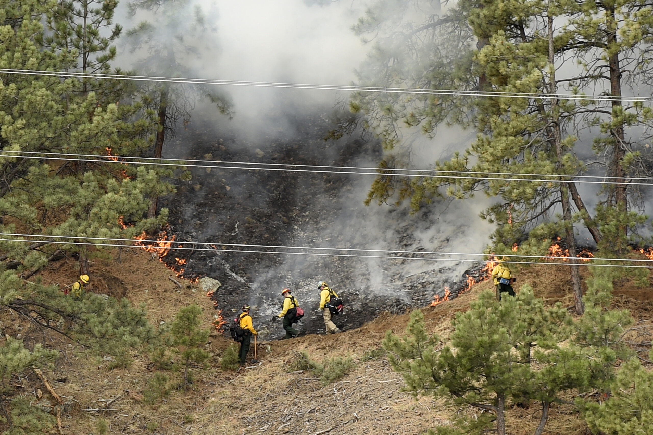 Crews battle the Sunshine Fire in the Sunshine canyon area of Boulder, Colo. on Sunday, March 19, 2017. The small wildfire forced people from their homes early Sunday and ignited dead trees that exploded into black plumes of smoke, authorities and residents said. (Jeremy Papasso/Daily Camera via AP) (AP)