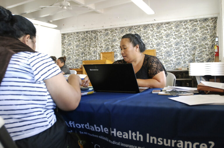 FILE - In this Jan. 30, 2017 file photo, Cinder Sonis, right, an advocate with Legal Aid Society of Hawaii, helps a customer enroll in an Affordable Care Act health insurance plan in Honolulu. Allowing insurers to market health care policies across state lines is one of President Donald Trump's main ideas for bringing down costs. While supporters of the idea cast it as a way to make insurance policies more competitive, critics say it's unlikely to result in more affordable plans and could undermine stronger consumer protections in states such as California and Hawaii. (AP Photo/Cathy Bussewitz, File) (AP)