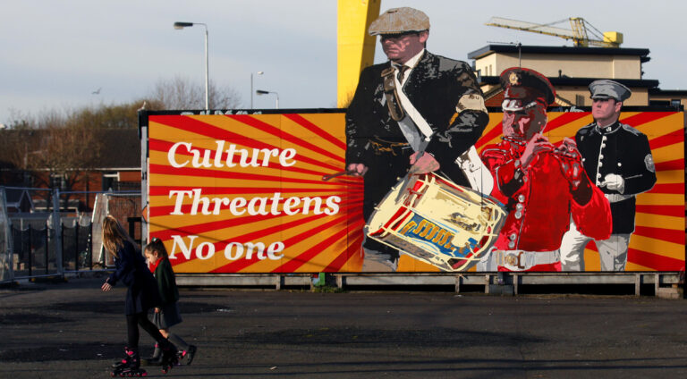 Children walks past a Loyalist mural in East Belfast a predominantly loyalist area in Belfast, Northern Ireland, Friday, March 24, 2017. Almost 20 years on from the Good Friday peace accord, which brought about the end of Northern Ireland's sectarian conflict, the city of Belfast has changed dramatically. Reminders of the past are everywhere _ murals and memorials to those killed in the conflict, along with peace walls that separate predominantly Protestant neighborhoods from mostly Catholic ones _ but there are also new shopping malls and cafes, new tech industries, and lots of tourists. (AP Photo/Peter Morrison) (AP)