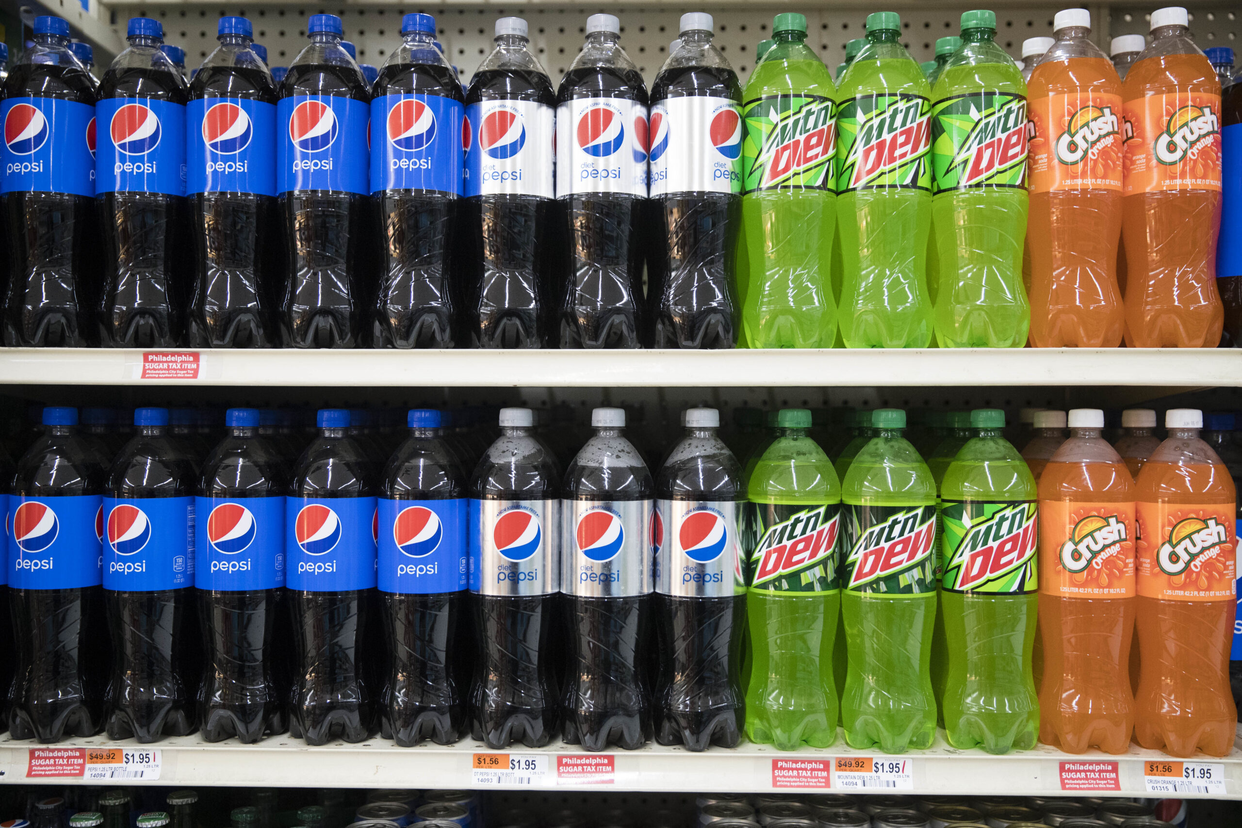 In this March 16, 2017 photo, sugar tax stickers are posted by sweetened beverages at the IGA supermarket in the Port Richmond neighborhood of Philadelphia. Less than three months into Philadelphia's new tax on sweetened drinks, the stakes have escalated: Beverage makers say the measure is hurting sales so much they need to cut jobs, while city officials say the moves are a ploy to get the tax struck down. (AP Photo/Matt Rourke) (AP Photo/Matt Rourke)