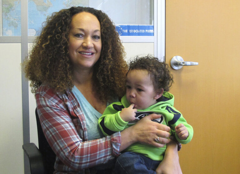 In this March 20, 2017 photo, Rachel Dolezal poses for a photo with her son, Langston in the bureau of the Associated Press in Spokane, Wash. Dolezal, who has legally changed her name to Nkechi Amare Diallo, rose to prominence as a black civil rights leader, but then lost her job when her parents exposed her as being white and is now struggling to make a living. (AP Photo/Nicholas K. Geranios) (AP)