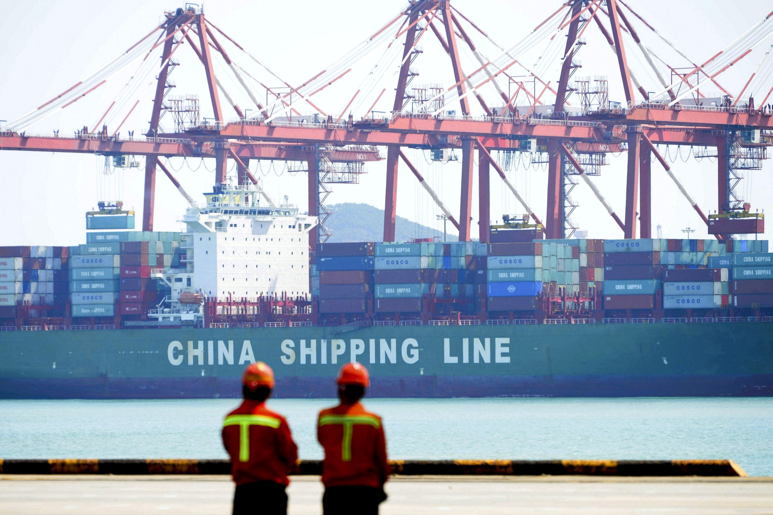 Workers stand watch as containers are loaded into a cargo ship at Qingdao Port in Qingdao in east China's Shandong province, Thursday, April 13, 2017. China's export growth accelerated in March in a positive sign for global demand, though import growth cooled. (Chinatopix via AP) (Chinatopix via AP)