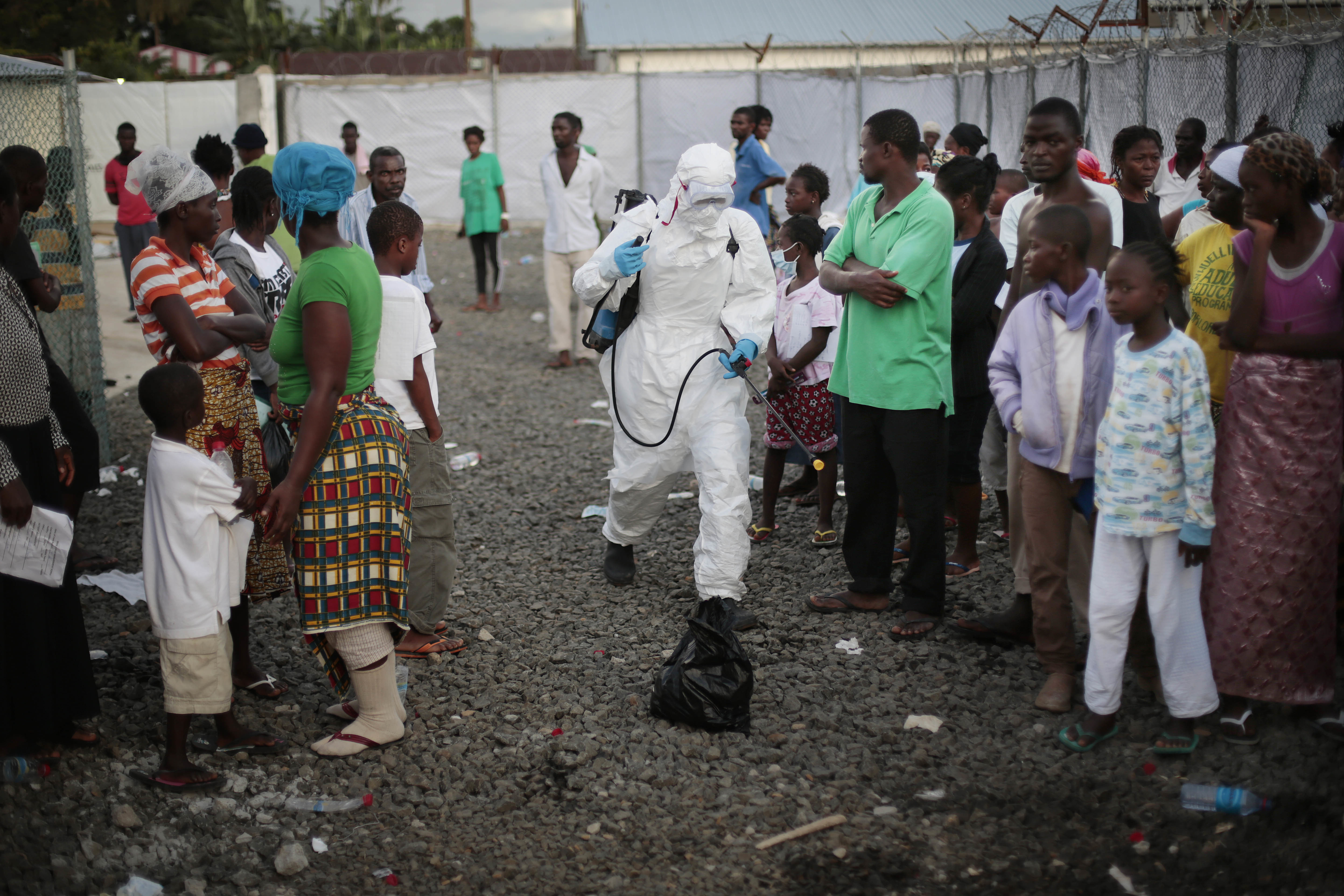 FILE - In this file photo daetd Tuesday, Sept. 30, 2014, a medical worker sprays people being discharged from the Island Clinic Ebola treatment center in Monrovia, Liberia. Bulldozers on Wednesday April. 5, 2017 cleared the remains of a once busy Ebola treatment unit in Liberia, as health care workers, officials and some who were treated there gathered to mark the center's last day and official decommissioning. (AP Photo/Jerome Delay, FILE) (AP)