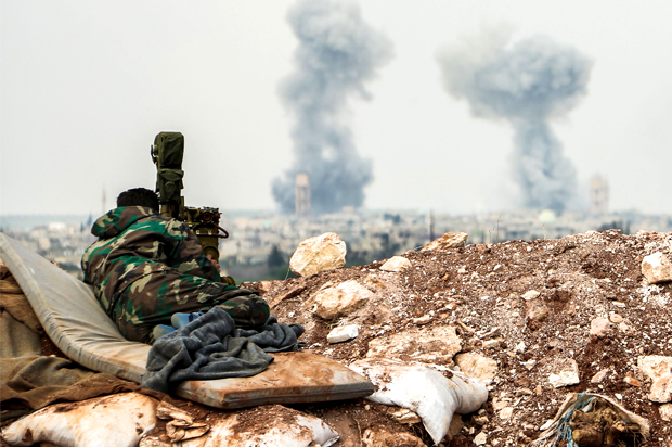 A Syrian forces' artillery observer looks through a scope as smoke plumes rise on the horizon, near the town of Qumhanah in the countryside of the central province of Hama, on April 1, 2017 (Getty/Stringer)