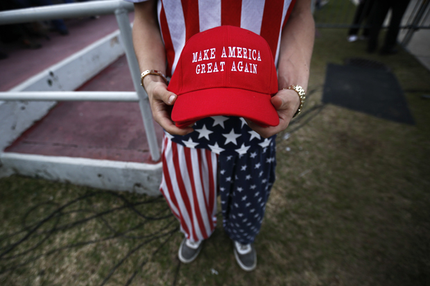 A man dressed in American flag clothes holds "Make America Great Again" hats before President-elect Donald Trump speaks at a rally at the Ladd–Peebles Stadium, Saturday, Dec. 17, 2016, in Mobile, Ala. (AP Photo/Brynn Anderson) (AP/Brynn Anderson)