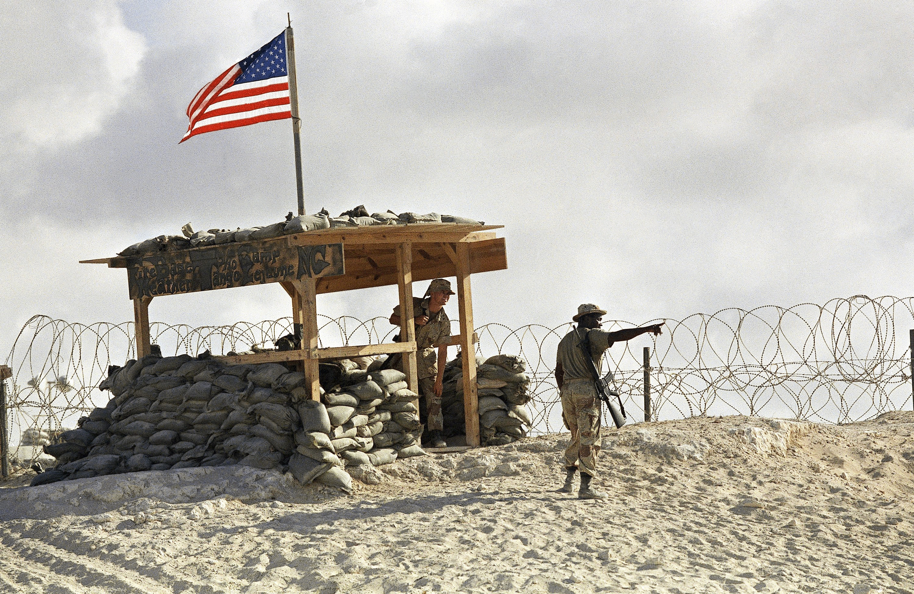 Stf. Sgt. Michael Lewis points out U.S. Navy ships on the Mogadishu coast on Wednesday, March 23, 1994. (APAP Photo/John Moore)