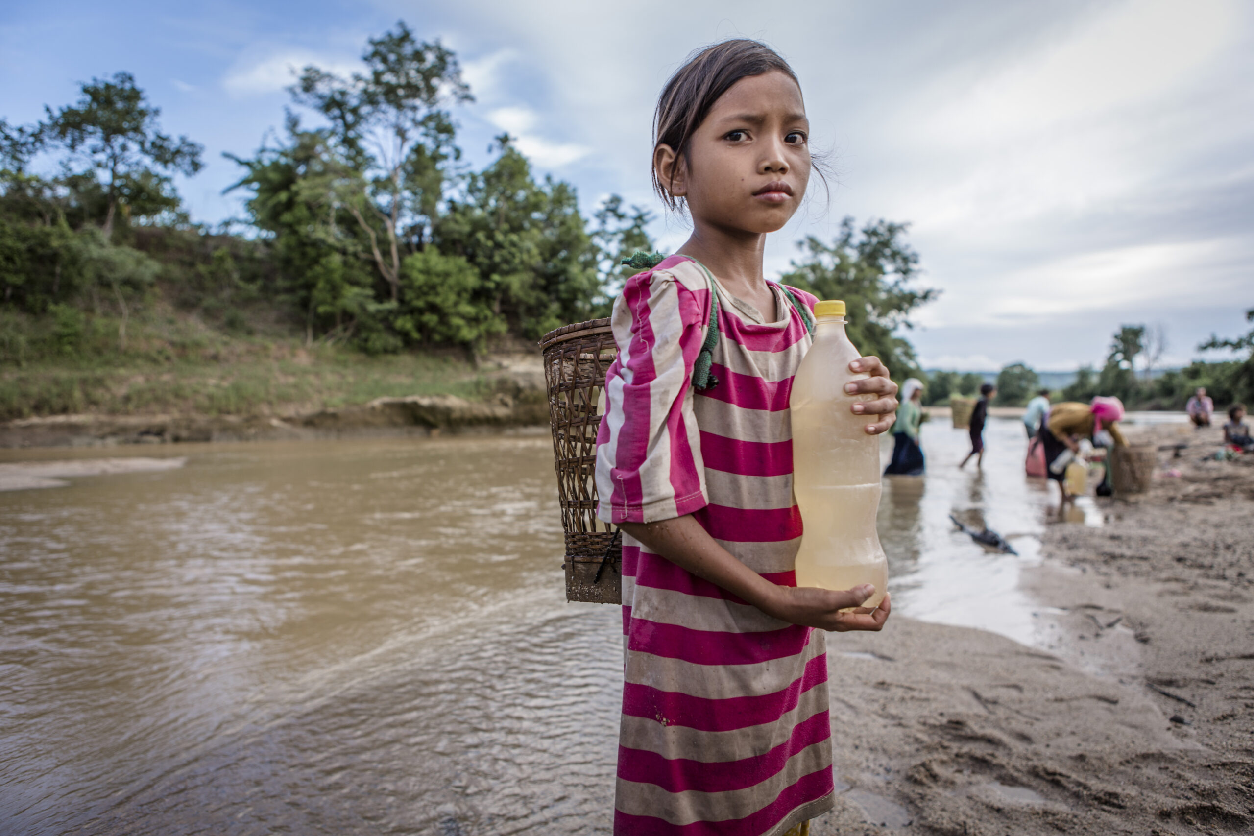 Dinh, 11. Like many children her age she is forced to collect drinking water from a nearby river. Now the rains have returned there is some water in the river, but it’s very shallow, making it muddy and unsafe to drink. When there is enough water, people can dig channels into the ground close to the river banks to find safer water, or use wells. (Jonathan Hyams)