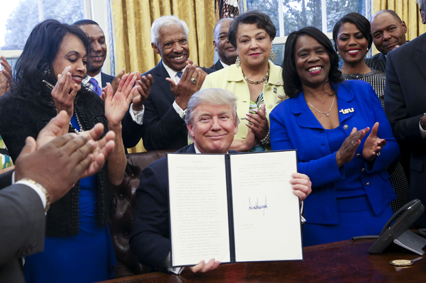 Donald Trump shows the signed executive order supporting black colleges and universities in the Oval Office, February 28, 2017. (Getty/Aude Guerrucci)