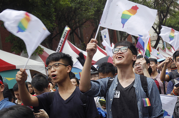 Same-sex marriage supporters wave rainbow Taiwan flags outside the Legislative Yuan in Taipei, Taiwan, May 24, 2017, after the Constitutional Court ruled in favor of same-sex marriage. (AP/Chiang Ying-ying)