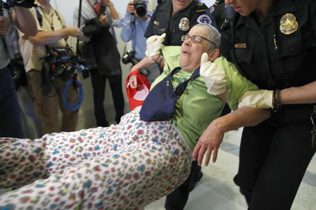 People are removed as they protest proposed cuts to Medicaid (AP/Jacquelyn Martin)