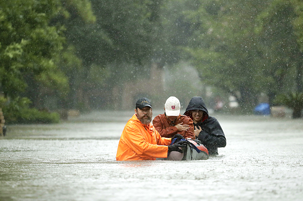 People evacuate a neighborhood inundated by floodwaters from Tropical Storm Harvey on Monday, Aug. 28, 2017, in Houston, Texas (AP/Charlie Riedel)