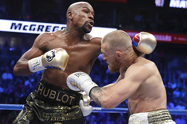 Floyd Mayweather Jr. fights Conor McGregor in a super welterweight boxing match. (AP/Isaac Brekken)