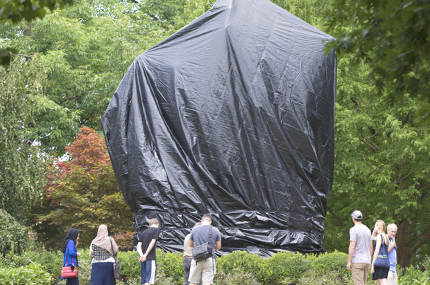 Residents and visitors look over the covered statue of Confederate General Robert E. Lee in Emancipation park in Charlottesville, Va., (AP/Steve Helber)