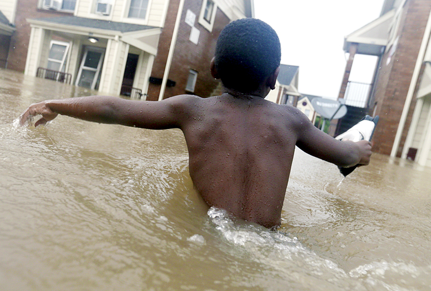 Jayveon Murphy makes his way through floodwaters from Harvey (AP/LM Otero)