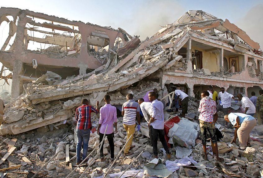 Somalis gather and search for survivors by destroyed buildings after a huge explosion from a truck bomb in the capital Mogadishu, Somalia, Oct. 14, 2017. (AP/Farah Abdi Warsameh)
