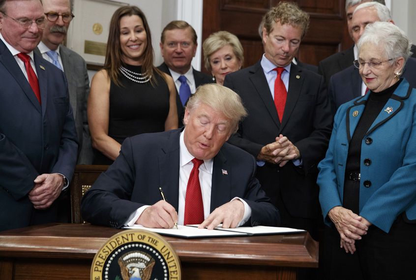 Dave Ratner, second from left, and others watch as President Donald Trump signs an executive order on health care in the Roosevelt Room of the White House, October 12, 2017. (AP/Evan Vucci)