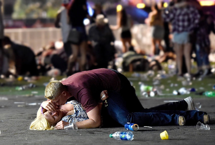 A man lays on top of a woman as others flee a country music festival after a shooting on October 1, 2017 (Getty/David Becker)