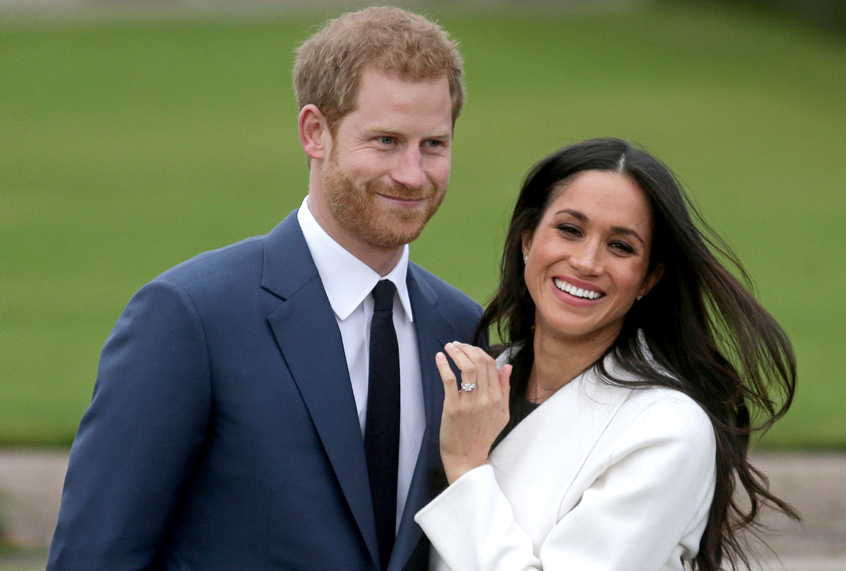 Prince Harry stands with his fiancée Meghan Markle as she shows off her engagement ring. (Getty/Daniel Leal-Olivas)