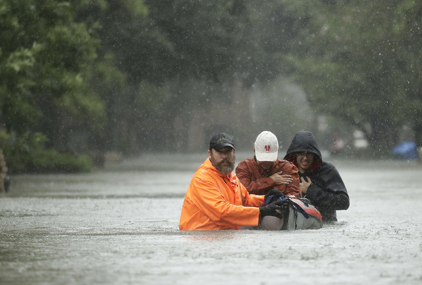 People evacuate a neighborhood inundated by floodwaters from Tropical Storm Harvey on Monday, Aug. 28, 2017, in Houston, Texas. (AP/Charlie Riedel)