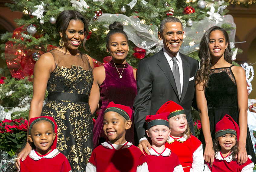 Michelle Obama, Sasha Obama, Barack Obama, and Malia Obama pose with "elves" (Getty/Kristoffer Tripplaar)