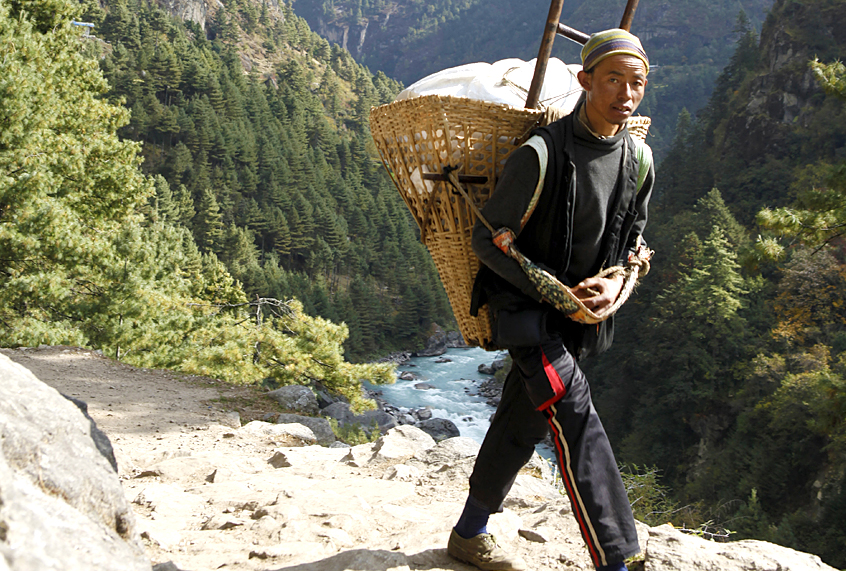 A local porter walks towards Lukla to fetch daily supplies. (AP/Tashi Sherpa)