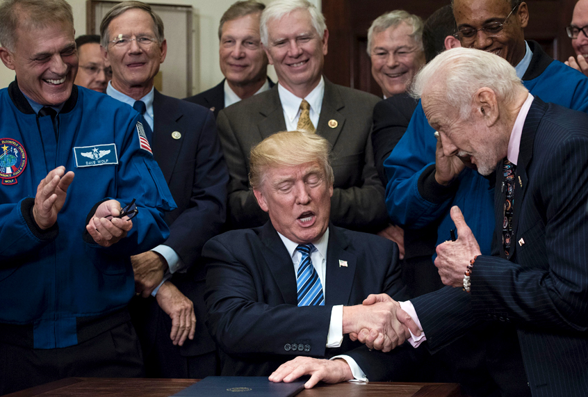 Donald Trump shakes former NASA Astronaut and second man on the moon, Buzz Aldrin's hand after signing an executive order to send American astronauts back to the moon, and eventually Mars. (Getty/Brendan Smialowsk)