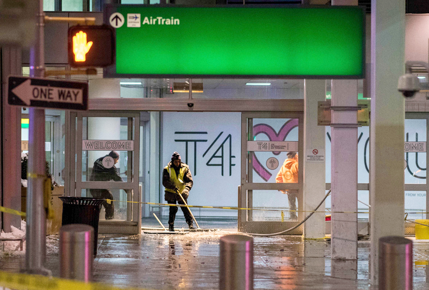 Workers sweep water from a floor of the arrivals area at John F. Kennedy International Airport's terminal 4 on January 7, 2018. (Getty/Jewel Samad)
