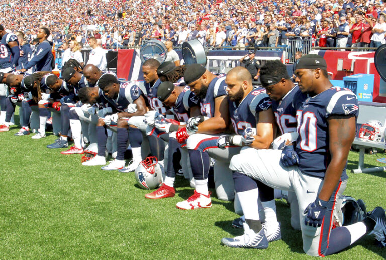 Members of the New England Patriots kneel during the National Anthem before a game (Getty/Jim Rogash)