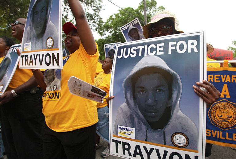 Protestors hold up signs in a march and rally for slain Florida teenager Trayvon Martin (AP/Julie Fletcher)