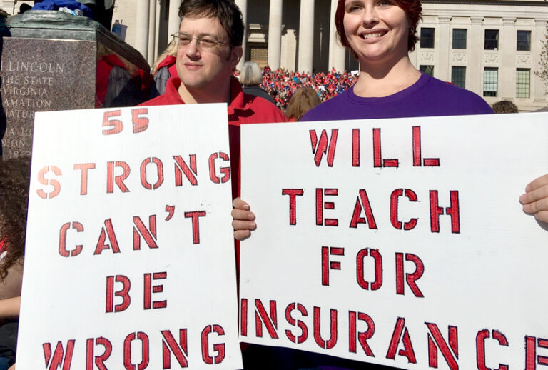 Teachers hold signs at a rally in Charleston, W.Va., Feb. 26, 2018. (AP/John Raby)