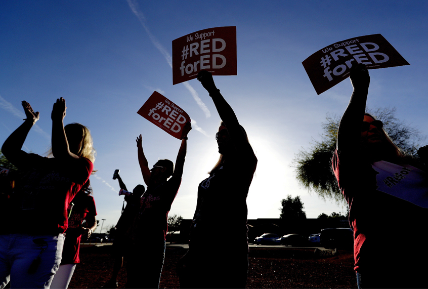 Teachers at Humphrey Elementary school participate in a state-wide walk-in prior to classes Wednesday, April 11, 2018, in Chandler, Ariz. (AP/Matt York)