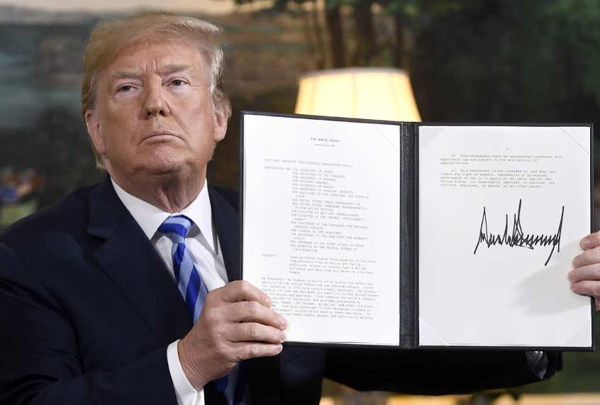 Donald Trump signs a document reinstating sanctions against Iran after announcing the US withdrawal from the Iran Nuclear deal. (Getty/Saul Loeb)