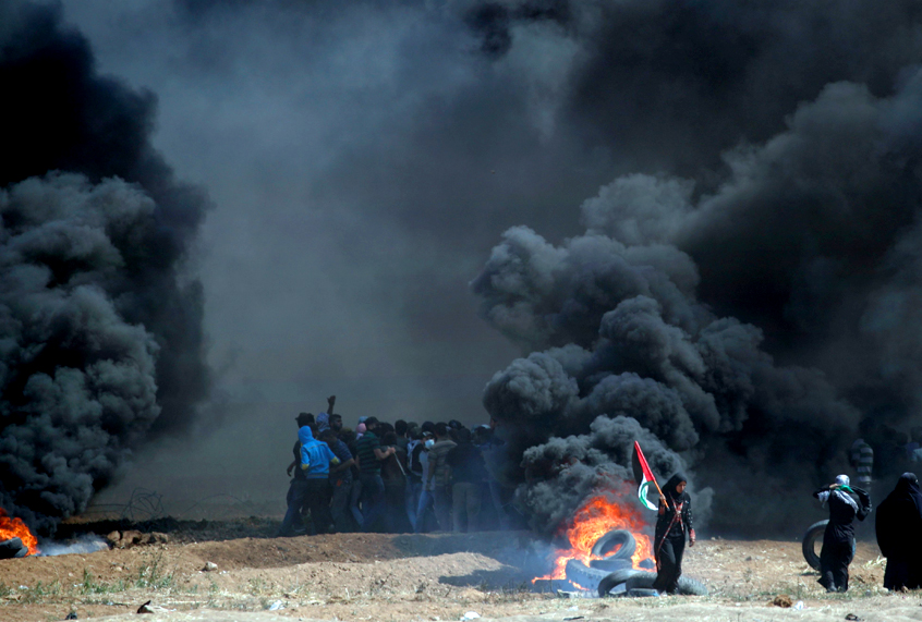 Palestinians clash with Israeli forces near the border between the Gaza strip and Israel, east of Gaza City following the the controversial move to Jerusalem of the United States embassy on May 14, 2018, (Getty/Thomas Coex)