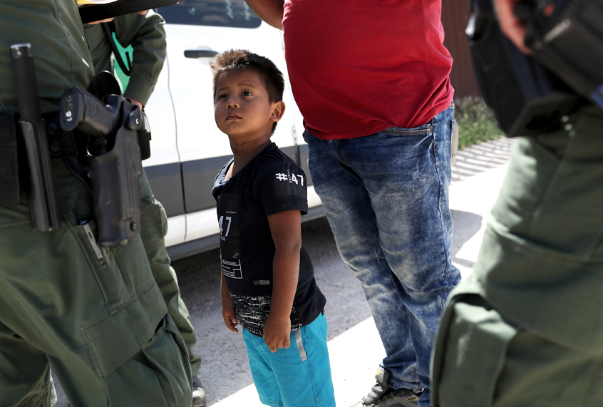 A boy and father from Honduras are taken into custody by U.S. Border Patrol agents near the U.S.-Mexico Border. (Getty/John Moore)