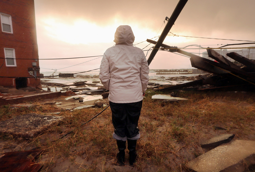 Resident Kim Johnson inspects the area around her apartment building after Hurricane Sandy. (Getty/Mario Tama)