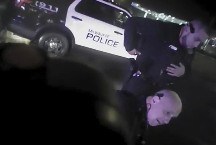 This Jan. 26, 2018, police body camera footage released by Milwaukee Police Department shows police officers holding down Milwaukee Bucks guard Sterling Brown after using a stun gun in a Walgreens parking lot in Milwaukee. (Milwaukee Police Department via AP)