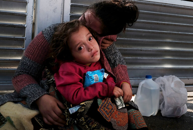 A Honduran child and her mother, fleeing poverty and violence in their home country, wait along the border bridge after being denied entry from Mexico into the U.S. (Getty/Spencer Platt)