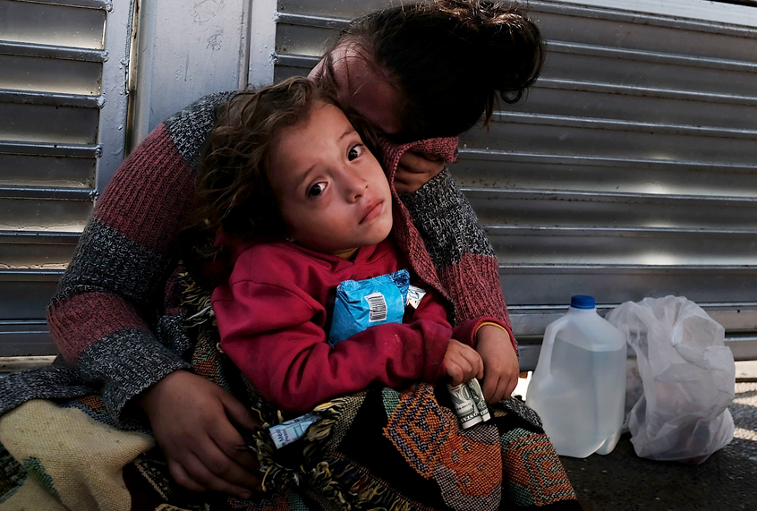 A Honduran child and her mother, fleeing poverty and violence in their home country, wait along the border bridge after being denied entry from Mexico into the U.S. (Getty/Spencer Platt)
