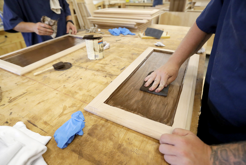 Inmates work on staining cabinet doors at the Habitat for Humanity Prison Build at the Ionia Correctional Facility in Ionia, Mich. (AP/Carlos Osorio)