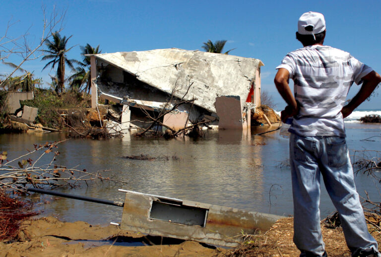 A man surveys a house that was washed away by heavy surf during the passing of Hurricane Maria in Manati, Puerto Rico on October 6, 2017. (Getty/Ricardo Arduengo)