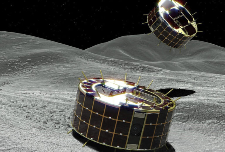 This computer graphic image provided by the Japan Aerospace Exploration Agency (JAXA) shows two drum-shaped and solar-powered Minerva-II-1 rovers on an asteroid. Japanese unmanned spacecraft Hayabusa2 released two small Minerva-II-1 rovers on the asteroid Ryugu on Friday, Sept. 21, 2018. (JAXA via AP)
