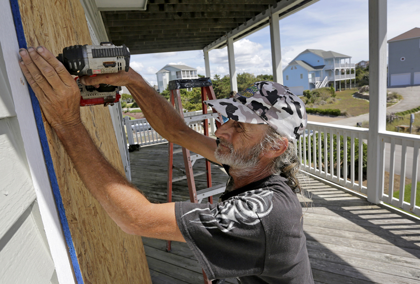 Joe Gore prepares for Hurricane Florence as he boards up windows on a home in Emerald Isle, N.C., Sept. 12, 2018. (AP/Tom Copeland)